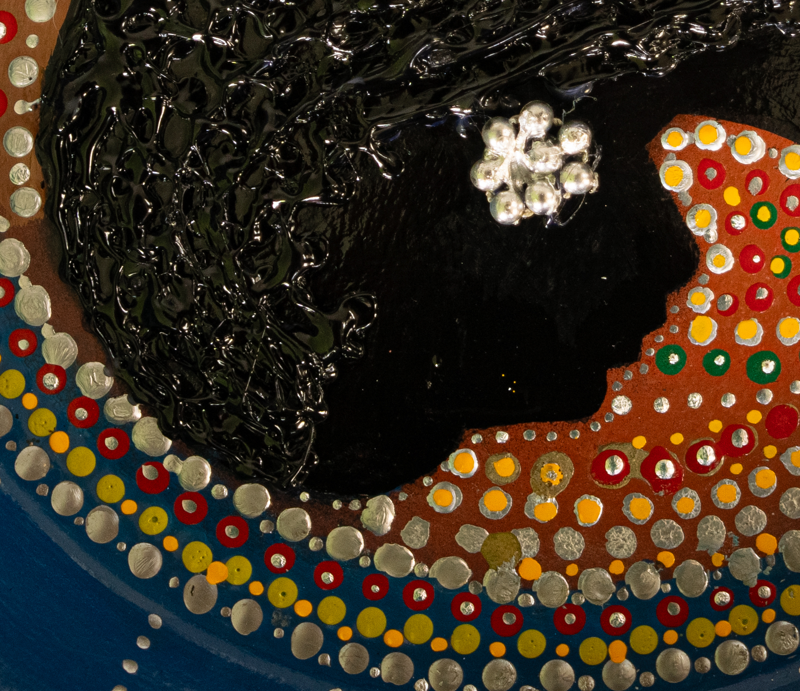 Textured black profile surrounded by concentric coloured dotted bands